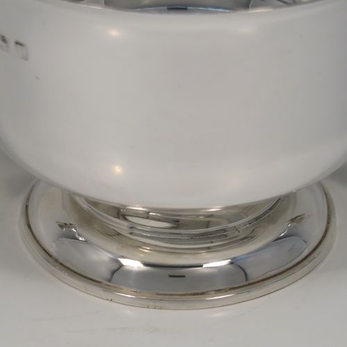 A very handsome Antique Sterling Silver trophy cup, having a plain round bellied body, with two scroll side-handles, and all sitting on a round pedestal foot. This elegant antique sterling silver trophy cup was made by William Hutton of Birmingham in 1912. The dimensions of this fine hand-made silver trophy cup are height 11 cms (4.3 inches), spread across arms 21 cms (8.25 inches), and it weighs approx. 495g (16 troy ounces).   