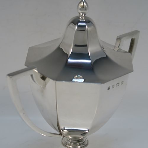 A very elegant Antique Edwardian Sterling Silver trophy cup and cover, having a plain octagonal panelled body with tapering sides, two side-handles with flat tops, an original cover with matching decoration and a pearl-drop finial, and all sitting on a panelled pedestal foot. This handsome silver trophy cup was made by A. and J. Zimmerman of Birmingham in 1909. The dimensions of this fine hand-made silver trophy cup and cover are height 18 cms (7 inches), spread across arms 16.5 cms (6.5 inches), and it weighs approx. 327g (10.5 troy ounces).