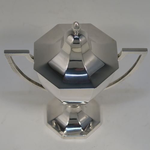 A very elegant Antique Edwardian Sterling Silver trophy cup and cover, having a plain octagonal panelled body with tapering sides, two side-handles with flat tops, an original cover with matching decoration and a pearl-drop finial, and all sitting on a panelled pedestal foot. This handsome silver trophy cup was made by A. and J. Zimmerman of Birmingham in 1909. The dimensions of this fine hand-made silver trophy cup and cover are height 18 cms (7 inches), spread across arms 16.5 cms (6.5 inches), and it weighs approx. 327g (10.5 troy ounces).