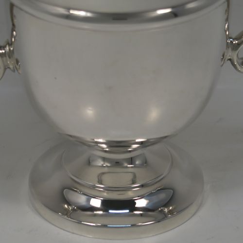 A very handsome Antique Sterling Silver trophy cup in a George III neoclassical style, having a round plain body with tapering sides and a tucked under belly, an applied central reeded band, two plain scroll side-handles, and all sitting on a stepped pedestal foot. This elegant silver trophy cup was made by George Harding and Sons of Sheffield in 1913. The dimensions of this fine hand-made silver trophy cup are height 17 cms (6.75 inches), spread across arms 20 cms (8 inches), and it weighs approx. 412g (13.3 troy ounces).