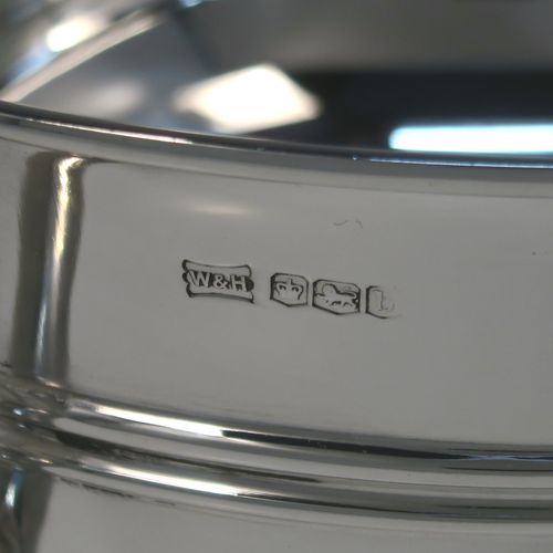 A very handsome Antique Sterling Silver trophy cup, having a plain round bellied body, with two scroll Anthemion leaf side-handles, with a central double-reeded girdle, and all sitting on a round pedestal foot. This elegant antique sterling silver trophy cup was made by Walker and Hall of Sheffield in 1919. The dimensions of this fine hand-made silver trophy cup bowl are height 15 cms (6 inches), spread across arms 31 cms (12.25 inches), and it weighs approx. 729g (23.5 troy ounces).  