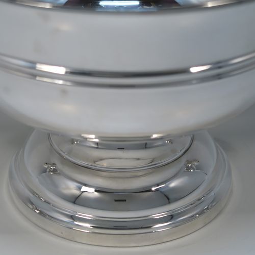 A very handsome Antique Sterling Silver trophy cup, having a plain round bellied body, with two scroll Anthemion leaf side-handles, with a central double-reeded girdle, and all sitting on a round pedestal foot. This elegant antique sterling silver trophy cup was made by Walker and Hall of Sheffield in 1919. The dimensions of this fine hand-made silver trophy cup bowl are height 15 cms (6 inches), spread across arms 31 cms (12.25 inches), and it weighs approx. 729g (23.5 troy ounces).  
