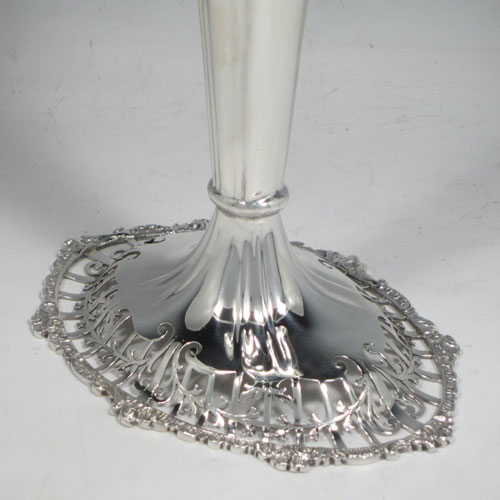 Sterling silver pair of very pretty table vases, having plain fluted bodies, with hand-pierced tops and applied cast floral and scroll borders, and sitting on matching hand-pierced pedestal feet. Made by Mappin and Webb of London in 1914. The dimensions of this fine hand-made silver pair of vases are height 27 cms (10.5 inches), width at top 13 cms (5 inches), and they weigh a total of 600g (19.3 troy ounces). Please note that these vases are not loaded.