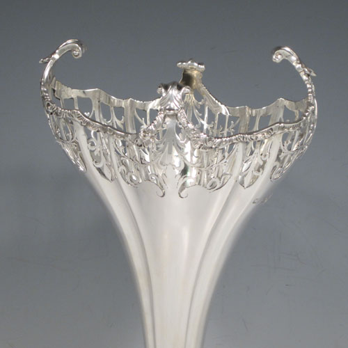 Sterling silver pair of very pretty table vases, having plain fluted bodies, with hand-pierced tops and applied cast floral and scroll borders, and sitting on matching hand-pierced pedestal feet. Made by Mappin and Webb of London in 1914. The dimensions of this fine hand-made silver pair of vases are height 27 cms (10.5 inches), width at top 13 cms (5 inches), and they weigh a total of 600g (19.3 troy ounces). Please note that these vases are not loaded.