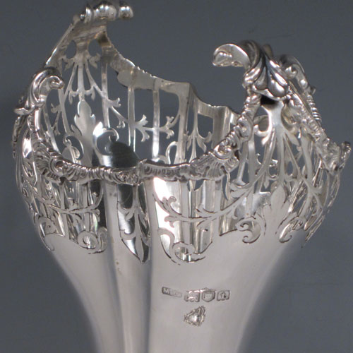 Sterling silver pair of very pretty table vases, having plain fluted bodies, with hand-pierced tops and applied cast floral and scroll borders, and sitting on matching hand-pierced pedestal feet. Made by Mappin and Webb of London in 1914. The dimensions of this fine hand-made silver pair of vases are height 27 cms (10.5 inches), width at top 13 cms (5 inches), and they weigh a total of 600g (19.3 troy ounces). Please note that these vases are not loaded.