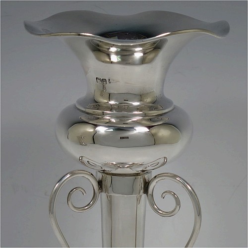 A very pretty and unusual pair of Antique Edwardian Sterling Silver Art Nouveau style vases, having removable central bodies, sitting in a frame with wire-work scrolls, attached to round bases with three scroll feet. Made by Walker and Hall of Sheffield in 1907. The dimensions of this fine pair of hand-made antique silver Art Nouveau vases are height 24 cms (9.5 inches), and diameter at bases 11 cms (4.3 inches). Please note that these vases are not loaded, and the total weight of silver is 640g (20.6 troy ounces)..