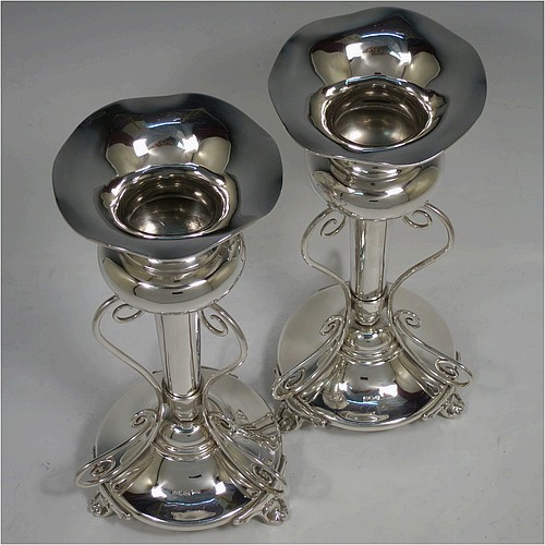 A very pretty and unusual pair of Antique Edwardian Sterling Silver Art Nouveau style vases, having removable central bodies, sitting in a frame with wire-work scrolls, attached to round bases with three scroll feet. Made by Walker and Hall of Sheffield in 1907. The dimensions of this fine pair of hand-made antique silver Art Nouveau vases are height 24 cms (9.5 inches), and diameter at bases 11 cms (4.3 inches). Please note that these vases are not loaded, and the total weight of silver is 640g (20.6 troy ounces)..