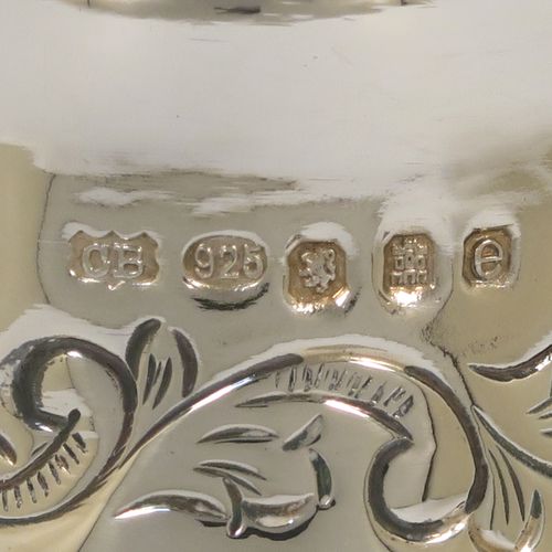 A pretty Scottish Sterling Silver large table flower vase, having a round bellied body, with hand-chased floral decoration, and sitting on a pedestal foot. This beautiful sterling silver single vase was made by the Cooper Brothers of Edinburgh in 2004. The dimensions of this fine hand-made silver vase are height 29 cms (11.5 inches), diameter of main body 12 cms (4.75 inches), and it weighs approx. 498g (16 troy ounces). Please note that this vase is not loaded.
