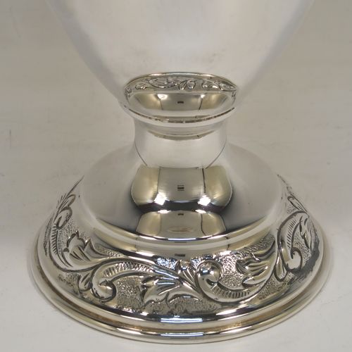 A pretty Scottish Sterling Silver large table flower vase, having a round bellied body, with hand-chased floral decoration, and sitting on a pedestal foot. This beautiful sterling silver single vase was made by the Cooper Brothers of Edinburgh in 2004. The dimensions of this fine hand-made silver vase are height 29 cms (11.5 inches), diameter of main body 12 cms (4.75 inches), and it weighs approx. 498g (16 troy ounces). Please note that this vase is not loaded.
