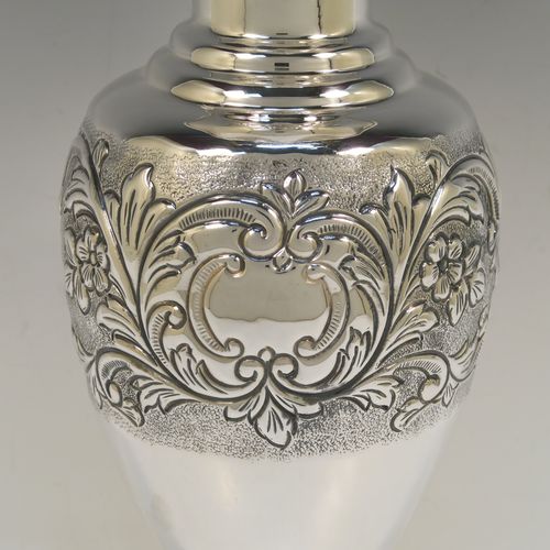 A pretty Scottish Sterling Silver large table flower vase, having a round bellied body, with hand-chased floral decoration, and sitting on a pedestal foot. This beautiful sterling silver single vase was made by the Cooper Brothers of Edinburgh in 2004. The dimensions of this fine hand-made silver vase are height 29 cms (11.5 inches), diameter of main body 12 cms (4.75 inches), and it weighs approx. 498g (16 troy ounces). Please note that this vase is not loaded.