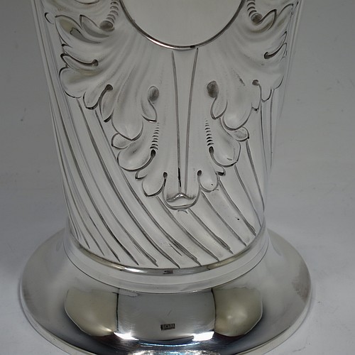 A very handsome Antique Victorian Sterling Silver large table flower vase, having a tapering round body, with hand-chased swirl fluted decoration, an oval vacant cartouche surrounded by hand-chased anthemion leaves and scrolls, with an upper band of gadroon rope-twist work, and sitting on a pedestal foot. Made by Thomas Bradbury of London in 1894. The dimensions of this fine hand-made antique silver vase are height 27.5 cms (10.75 inches), diameter at top 13 cms (5 inches), and it weighs approx. 433g (14 troy ounces). Please note that this vase is not loaded.