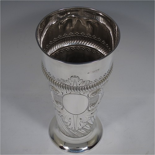 A very handsome Antique Victorian Sterling Silver large table flower vase, having a tapering round body, with hand-chased swirl fluted decoration, an oval vacant cartouche surrounded by hand-chased anthemion leaves and scrolls, with an upper band of gadroon rope-twist work, and sitting on a pedestal foot. Made by Thomas Bradbury of London in 1894. The dimensions of this fine hand-made antique silver vase are height 27.5 cms (10.75 inches), diameter at top 13 cms (5 inches), and it weighs approx. 433g (14 troy ounces). Please note that this vase is not loaded.