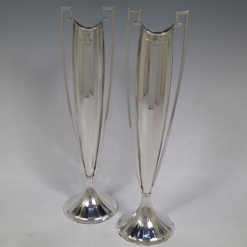 A very unusual and pretty pair of Art Deco Sterling Silver table flower vases, having tall panelled bodies with square cross-section side handles, and sitting on pedestal feet. Made by William Henry Sparrow of Birmingham in 1938. The dimensions of these fine hand-made pair of Art Deco silver vases are height 30 cms (11.75 inches), and diameter at base 8 cms (3.25 inches).   