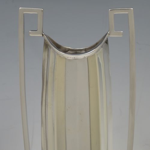 A very unusual and pretty pair of Art Deco Sterling Silver table flower vases, having tall panelled bodies with square cross-section side handles, and sitting on pedestal feet. Made by William Henry Sparrow of Birmingham in 1938. The dimensions of these fine hand-made pair of Art Deco silver vases are height 30 cms (11.75 inches), and diameter at base 8 cms (3.25 inches).
