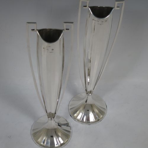 A very unusual and pretty pair of Art Deco Sterling Silver table flower vases, having tall panelled bodies with square cross-section side handles, and sitting on pedestal feet. Made by William Henry Sparrow of Birmingham in 1938. The dimensions of these fine hand-made pair of Art Deco silver vases are height 30 cms (11.75 inches), and diameter at base 8 cms (3.25 inches).