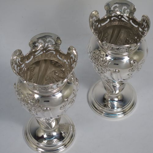A very pretty pair of Antique Victorian Sterling Silver Art Nouveau style vases, having hand-chased floral and scroll decoration, with hand-pierced upper necks and applied scroll borders, and all sitting on round stepped pedestal feet. Made by Walter and Charles Sissons of London in 1900. The dimensions of this fine pair of hand-made antique silver Art Nouveau vases are height 17 cms (6.75 inches), and diameter at top 7 cms (2.75 inches). Please note that these vases are not loaded, and the total weight of silver is 422g (13.6 troy ounces).