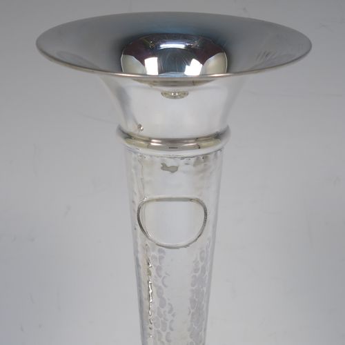 A handsome and stylish Antique Sterling Silver pair of table flower vases, having plain round tops, tapering bodies with hand-hammered decoration and oval vacant cartouches, and sitting on round stepped pedestal bases. Made by Walker and Hall of Sheffield in 1919. The dimensions of these fine hand-made pair of antique silver vases are height 22 cms (8.5 inches), and diameter at top 9 cms (3.5 inches).