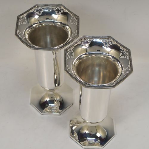 A very pretty pair of Sterling Silver table flower vases, having plain round bodies with tapering sides, with hand-pierced and applied rope-twist top borders, and sitting on plain hexagonal pedestal feet. These beautiful silver vases were made by Walker and Hall of Sheffield in 1924. The dimensions of this fine hand-made silver pair of vases are height 19 cms (7.5 inches), and width at top 10 cms (4 inches).