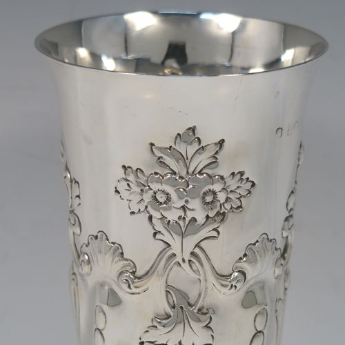 A large and very pretty Antique Victorian Sterling Silver table flower vase, having a round body with tapering sides and hand-chased floral and swirl-fluted decoration, and all sitting on a pedestal feet. This beautiful antique silver vase was made by the Harris Brothers of London in 1897. The dimensions of this fine hand-made antique silver vase are height 22 cms (8.75 inches), diameter at top 10 cms (4 inches), and it weighs approx. 320g (10.3 troy ounces). Please note that this vase is not loaded, so the whole weight is silver.