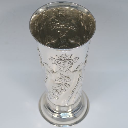 A large and very pretty Antique Victorian Sterling Silver table flower vase, having a round body with tapering sides and hand-chased floral and swirl-fluted decoration, and all sitting on a pedestal feet. This beautiful antique silver vase was made by the Harris Brothers of London in 1897. The dimensions of this fine hand-made antique silver vase are height 22 cms (8.75 inches), diameter at top 10 cms (4 inches), and it weighs approx. 320g (10.3 troy ounces). Please note that this vase is not loaded, so the whole weight is silver.