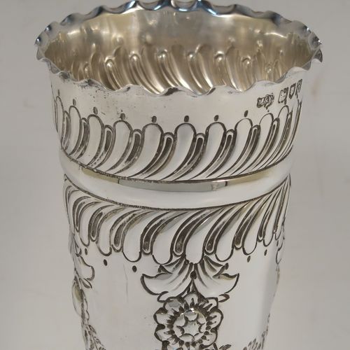 A very pretty Antique Victorian Sterling Silver pair of table flower vases, having round hand-chased bodies with tapering sides, with floral and fluted decoration, and all sitting on pedestal feet. These beautiful antique silver vases were made by Mappin and Webb of London in 1896. The dimensions of these fine hand-made antique silver pair of vases are height 16 cms (6.25 inches), diameter at top 6.5 cms (2.5 inches), and they weigh at total of approx. 200g (6.5 troy ounces). Please note that these vases are not loaded, so the whole weight is silver.