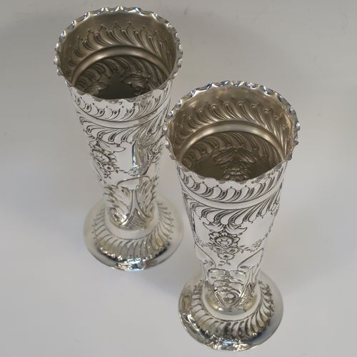 A very pretty Antique Victorian Sterling Silver pair of table flower vases, having round hand-chased bodies with tapering sides, with floral and fluted decoration, and all sitting on pedestal feet. These beautiful antique silver vases were made by Mappin and Webb of London in 1896. The dimensions of these fine hand-made antique silver pair of vases are height 16 cms (6.25 inches), diameter at top 6.5 cms (2.5 inches), and they weigh at total of approx. 200g (6.5 troy ounces). Please note that these vases are not loaded, so the whole weight is silver.