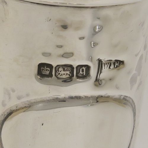 A handsome and stylish Antique Edwardian Sterling Silver pair of table flower vases, having plain round tops, tapering bodies with hand-hammered decoration and oval vacant cartouches, and sitting on round stepped pedestal bases. These elegant silver vases were made by Walker and Hall of Sheffield in 1909. The dimensions of these fine hand-made pair of antique silver vases are height 22 cms (8.5 inches), and diameter at top 9 cms (3.5 inches).