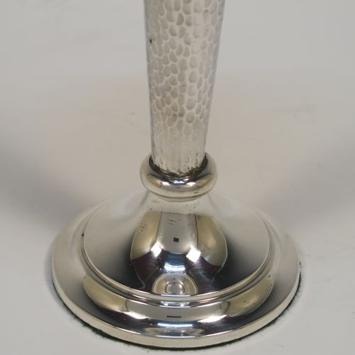 A handsome and stylish Antique Edwardian Sterling Silver pair of table flower vases, having plain round tops, tapering bodies with hand-hammered decoration and oval vacant cartouches, and sitting on round stepped pedestal bases. These elegant silver vases were made by Walker and Hall of Sheffield in 1909. The dimensions of these fine hand-made pair of antique silver vases are height 22 cms (8.5 inches), and diameter at top 9 cms (3.5 inches).