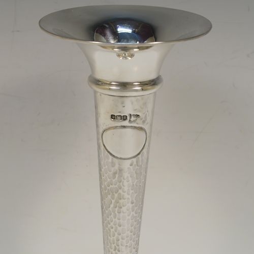 A handsome and stylish Antique Edwardian Sterling Silver pair of table flower vases, having plain round tops, tapering bodies with hand-hammered decoration and oval vacant cartouches, and sitting on round stepped pedestal bases. These elegant silver vases were made by Walker and Hall of Sheffield in 1909. The dimensions of these fine hand-made pair of antique silver vases are height 22 cms (8.5 inches), and diameter at top 9 cms (3.5 inches).