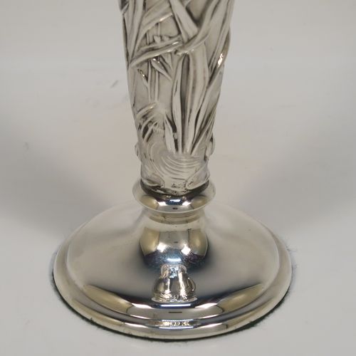 A very pretty Antique Edwardian Sterling Silver pair of table flower vases, having round hand-chased bodies with tapering sides and floral decoration, and all sitting on pedestal feet. These beautiful antique silver vases were made by William Comyns of London in 1903. The dimensions of these fine hand-made antique silver pair of vases are height 16.5 cms (6.5 inches), and diameter at top 7 cms (2.75 inches).
