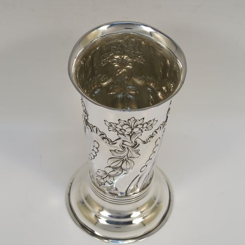 A very pretty Antique Victorian Sterling Silver table flower vase, having a round body with tapering sides and hand-chased floral and swirl-fluted decoration, and all sitting on pedestal feet. This beautiful antique silver vase was made by Charles Stuart Harris of London in 1899. The dimensions of these fine hand-made antique silver vase are height 15 cms (6 inches), diameter at top 7.5 cms (3 inches), and it weighs approx. 172g (5.5 troy ounces). Please note that this vase is not loaded, so the whole weight is silver.