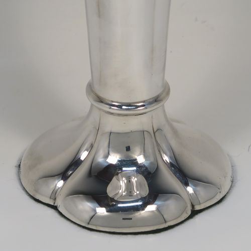 A very handsome Antique Edwardian Sterling Silver table flower vase, having a plain tapering round body with four hand-chased fluted panels, and sitting on a quattro foil pedestal foot. This elegant antique silver flower vase was made by Horace Woodward of London in 1910. The dimensions of this fine hand-made antique silver vase are height 18 cms (7 inches), and diameter at top 10 cms (4 inches).
