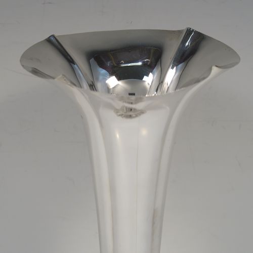 A very handsome Antique Edwardian Sterling Silver table flower vase, having a plain tapering round body with four hand-chased fluted panels, and sitting on a quattro foil pedestal foot. This elegant antique silver flower vase was made by Horace Woodward of London in 1910. The dimensions of this fine hand-made antique silver vase are height 18 cms (7 inches), and diameter at top 10 cms (4 inches).