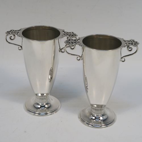 A very elegant pair of Antique Victorian Sterling Silver vases, having plain round bodies with tapering sides, with two scroll side handles and hand-pierced thumb-pieces, and all sitting on round pedestal feet. These handsome silver vases were made by Martin Hall and Co. Ltd., of Sheffield in 1896. The dimensions of these fine hand-made antique silver vases are height 12.5 cms (5 inches), spread across handles 10 cms (4 inches), diameter of bodies at lip 5.5 cms (2.25 inches), and they weigh approx. 277g (8.9 troy ounces). Please note that these vases are not loaded.