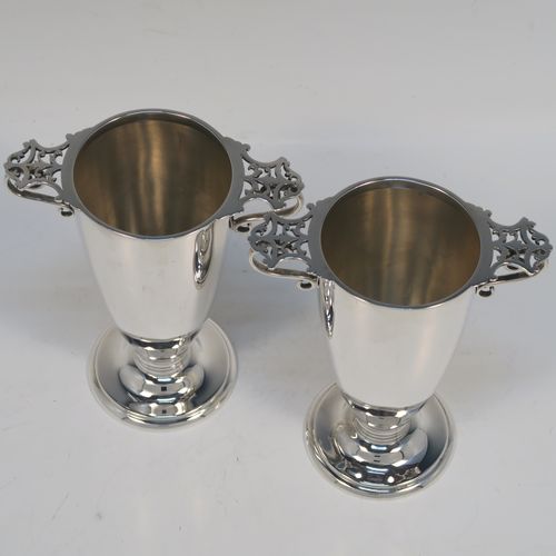 A very elegant pair of Antique Victorian Sterling Silver vases, having plain round bodies with tapering sides, with two scroll side handles and hand-pierced thumb-pieces, and all sitting on round pedestal feet. These handsome silver vases were made by Martin Hall and Co. Ltd., of Sheffield in 1896. The dimensions of these fine hand-made antique silver vases are height 12.5 cms (5 inches), spread across handles 10 cms (4 inches), diameter of bodies at lip 5.5 cms (2.25 inches), and they weigh approx. 277g (8.9 troy ounces). Please note that these vases are not loaded.