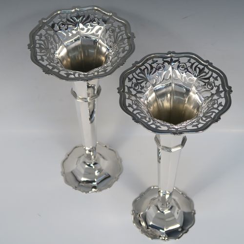 A very handsome and large pair of Antique Edwardian Sterling Silver table flower vases, having plain octagonal panelled bodies with tapering sides, with hand-pierced floral and scroll style decoration at the top, and sitting on pedestal feet with applied scroll borders. These elegant silver vases were made by Goldsmiths and Silversmiths of London in 1907. The dimensions of these fine hand-made antique silver pair of vases are height 26 cms (10.25 inches), diameter at top 12 cms (4.75 inches), and they weigh a total of 440g (14.2 troy ounces). Please note that these are not loaded, so the whole weight is silver.