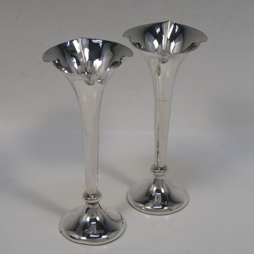 A handsome Antique Edwardian Sterling Silver pair of table flower vases, having very plain round tapering bodies, with petal-shaped mouths, and sitting on round pedestal feet, all in their original blue satin and velvet-line presentation box. These elegant silver vases were made by James Dixon and Sons of Sheffield in 1907. The dimensions of these fine hand-made pair of antique silver vases are height 14,5 cms (5.75 inches), and diameter at top 6 cms (2.3 inches).