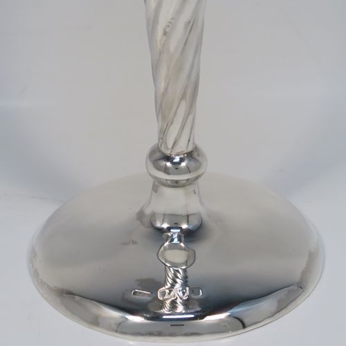 A very pretty pair of Antique Victorian Sterling Silver table flower vases, having round bodies with tapering sides and hand-chased swirl-fluted decoration, and sitting on plain round pedestal feet. These elegant silver vases were made by Stokes and Ireland of Chester in 1900. The dimensions of these fine hand-made antique silver pair of vases are height 20 cms (8 inches), and diameter at top 8 cms (3 inches).