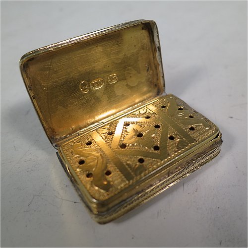 An Antique Georgian Sterling Silver and gold-gilt vinaigrette, having a rectangular body with hand-engraved floral decoration, a hinged lid, a gold-gilt interior with hinged geometrically pierced and engraved grill. Made by Joseph Wilmore, of Birmingham in 1812. The dimensions of this fine hand-made antique silver vinaigrette are length 3.2 cms (1.25 inches), width 2 cms (0.75 inches), and depth 0.8 cms (0.3 inches).