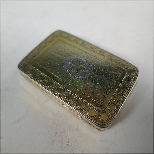 An Antique Georgian Sterling Silver and gold-gilt vinaigrette, having a rectangular body with hand-engraved floral decoration, a hinged lid, a gold-gilt interior with hinged geometrically pierced and engraved grill. Made by Joseph Wilmore, of Birmingham in 1812. The dimensions of this fine hand-made antique silver vinaigrette are length 3.2 cms (1.25 inches), width 2 cms (0.75 inches), and depth 0.8 cms (0.3 inches).