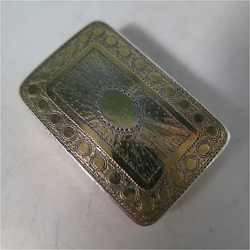 An Antique Georgian Sterling Silver and gold-gilt vinaigrette, having a rectangular body with hand-engraved floral decoration, a hinged lid, a gold-gilt interior with hinged geometrically pierced and engraved grill. Made by Joseph Wilmore, of Birmingham in 1812. The dimensions of this fine hand-made antique silver vinaigrette are length 3.2 cms (1.25 inches), width 2 cms (0.75 inches), and depth 0.8 cms (0.3 inches).
