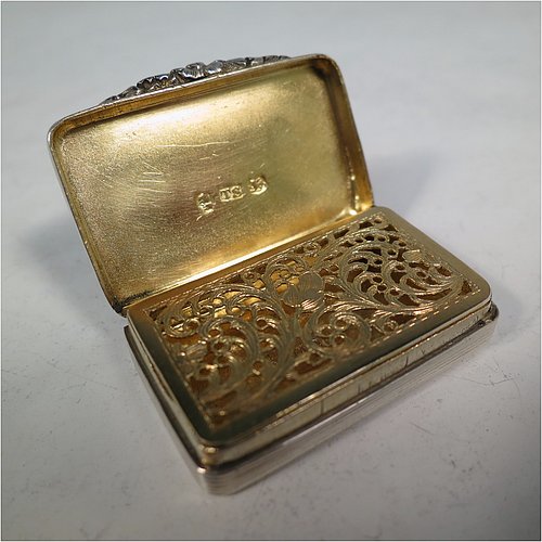 An Antique Georgian Sterling Silver vinaigrette, having machine-engraved decoration on the top and base, with hand-chased reeded edges and a cast floral thumb-piece, a gold-gilt interior, and a hand-pierced floral style grill. Made by Thomas Shaw of Birmingham in 1829. The dimensions of this fine hand-made antique silver vinaigrette are length 4 cms (1.5 inch), width 2.5 cm (1 inch), and depth 0.8 cm (0.3 inches).