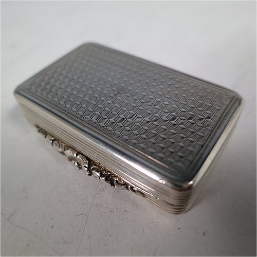 An Antique Georgian Sterling Silver vinaigrette, having machine-engraved decoration on the top and base, with hand-chased reeded edges and a cast floral thumb-piece, a gold-gilt interior, and a hand-pierced floral style grill. Made by Thomas Shaw of Birmingham in 1829. The dimensions of this fine hand-made antique silver vinaigrette are length 4 cms (1.5 inch), width 2.5 cm (1 inch), and depth 0.8 cm (0.3 inches).