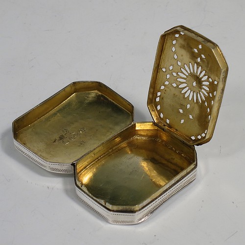 An Antique Georgian Sterling Silver vinaigrette, having a rectangular cut-cornered concave body with hand-engraved three-leaf clovers decoration on the top and floral decoration on the base, a gold-gilt interior, and a sun-motif hand-pierced grill. Made by Samuel Pemberton of Birmingham in 1809. The dimensions of this fine hand-made antique silver vinaigrette are length 4 cms (1.5 inch), width 3 cm (1.25 inch), and depth 1.2 cm (0.5 inches).