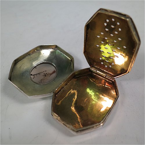 An Antique Georgian Sterling Silver vinaigrette, having an octagonal body with a mounted oval moss agate, surrounded by hand-engraved bands and floral decoration, a plain base, a gold-gilt interior, and a plain hand-pierced grill. Made by Joseph Wilmore Birmingham in 1812. The dimensions of this fine hand-made antique silver vinaigrette are length 4 cms (1.5 inches), width 3 cms (1.25 inches), and depth 2 cms (0.75 inches).
