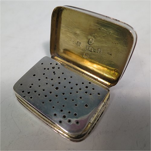 An Antique Georgian Sterling Silver vinaigrette, having hand-engraved greek-key decoration on the top and hand-engraved floral decoration on the base, a gold-gilt interior, and a plain hand-pierced grill. Made by John Shaw of Birmingham in 1803. The dimensions of this fine hand-made antique silver vinaigrette are length 3.5 cms (1.3 inch), width 2.2 cm (1 inch), and depth 0.8 cm (0.3 inches).   