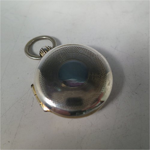 An Antique Georgian Sterling Silver vinaigrette, having a round body in the shape of a fob watch, with engine-turned decoration on the top and base, a hinged lid with ring for a chain, and a gold-gilt interior with a plain hand-pierced grill. Made by John Lawrence, of Birmingham in 1828. The dimensions of this fine hand-made antique silver vinaigrette are diameter length 2.5 cms (1 inch), and depth 0.8 cms (0.3 inches).   