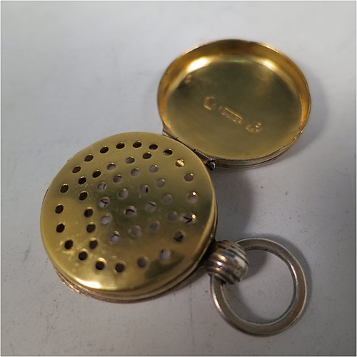 An Antique Georgian Sterling Silver vinaigrette, having a round body in the shape of a fob watch, with engine-turned decoration on the top and base, a hinged lid with ring for a chain, and a gold-gilt interior with a plain hand-pierced grill. Made by John Lawrence, of Birmingham in 1828. The dimensions of this fine hand-made antique silver vinaigrette are diameter length 2.5 cms (1 inch), and depth 0.8 cms (0.3 inches).   
