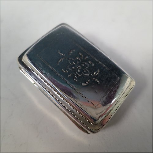 An Antique Georgian Sterling Silver vinaigrette, having a rectangular body with an applied raspberry and leaf motif surrounded by hand-engraved stipple-work on top and hand-engraved floral work on the base, a gold-gilt interior, and a hand-pierced floral grill. Made by John Bettridge of Birmingham in ca. 1820. The dimensions of this fine hand-made antique silver vinaigrette are length 3.5 cms (1.4 inches), width 2.5 cms (1 inch), and depth 1.2 cms (0.5 inch).