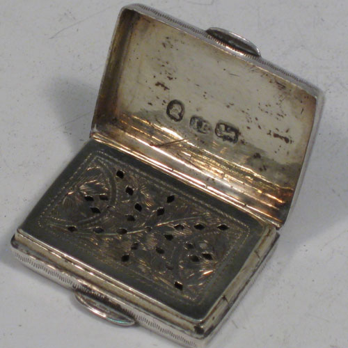 Antique Georgian sterling silver purse-form vinaigrette, having a rectangular body with hand-engraved decoration, a hinged lid, a gold-gilt interior with hinged hand-pierced and chased grill with floral decoration. Made by John Bettridge of Birmingham in 1833. The dimensions of this fine hand-made silver vinaigrette are length 3 cms (1.25 inches), and width 2 cms (0.75 inches).